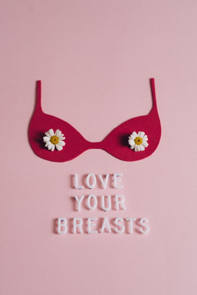 Conceptual art piece promoting breast cancer awareness with pink background and affirming message.